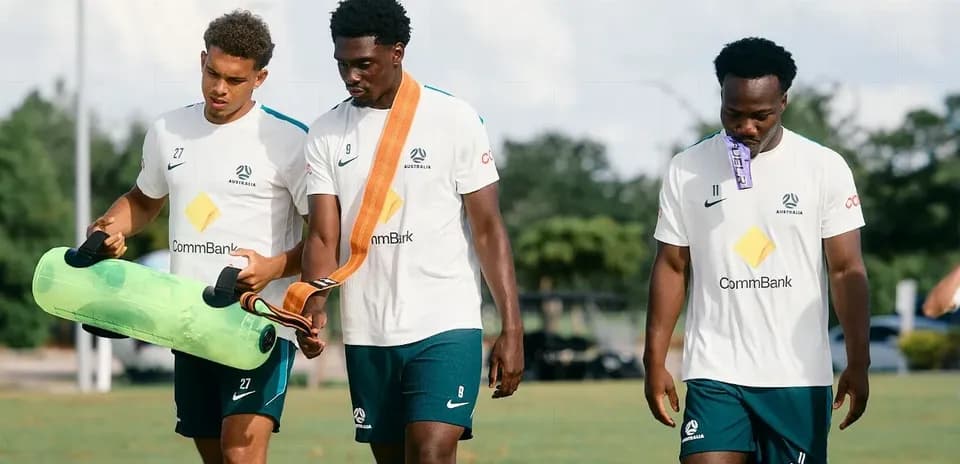 Üç futbolçu məşq avadanlıqları daşıyır