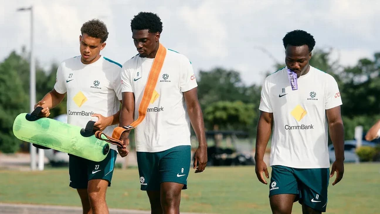Üç futbolçu məşq avadanlıqları daşıyır