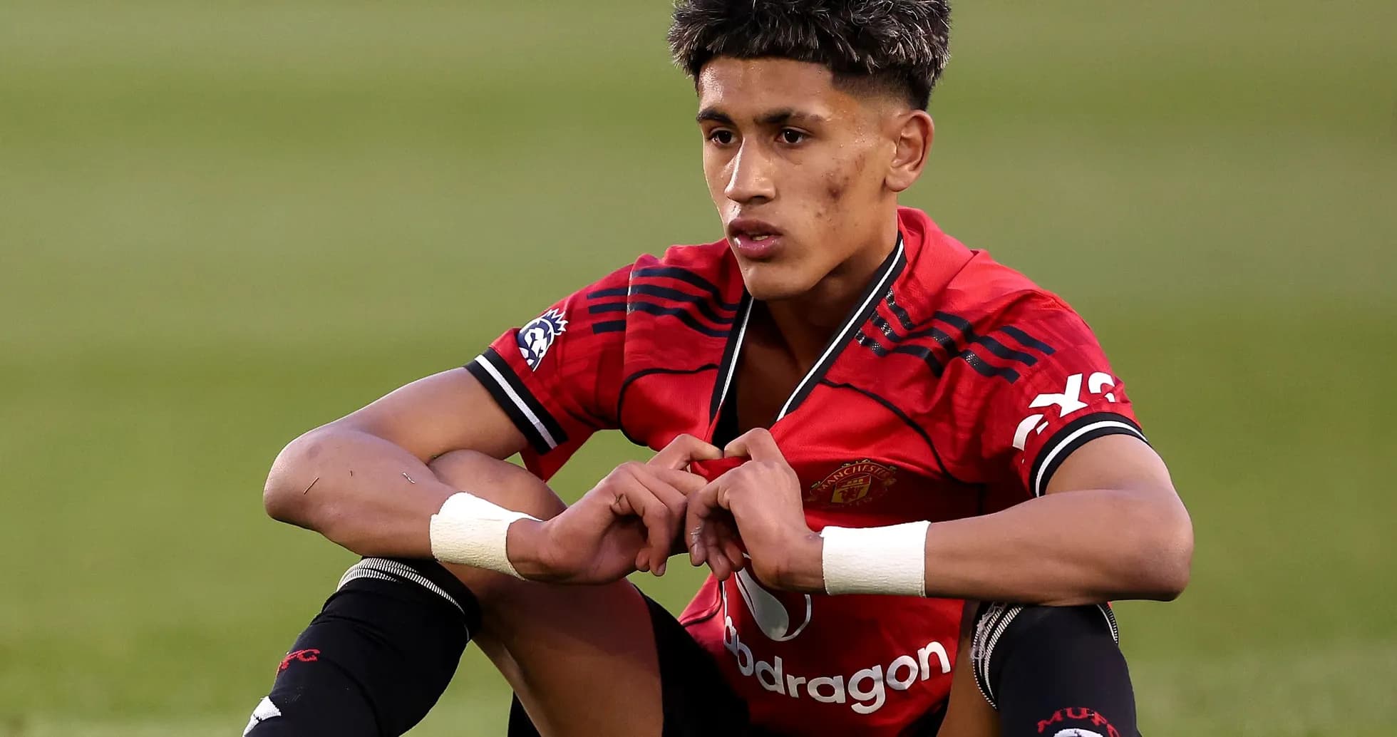 Futbolçu Manchester United forması ilə oturur