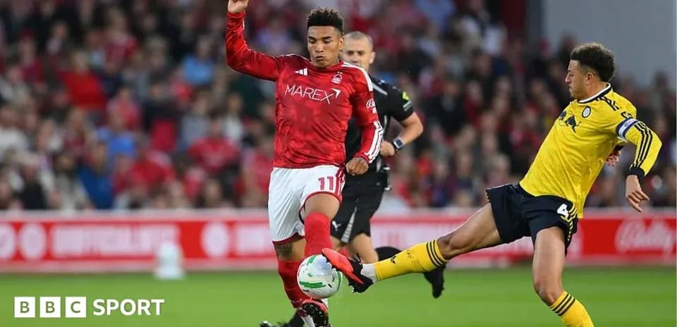 Player in red shirt tackles opponent in yellow jersey