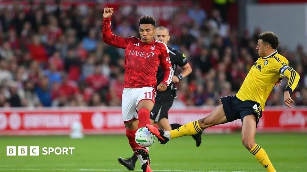Player in red shirt tackles opponent in yellow jersey