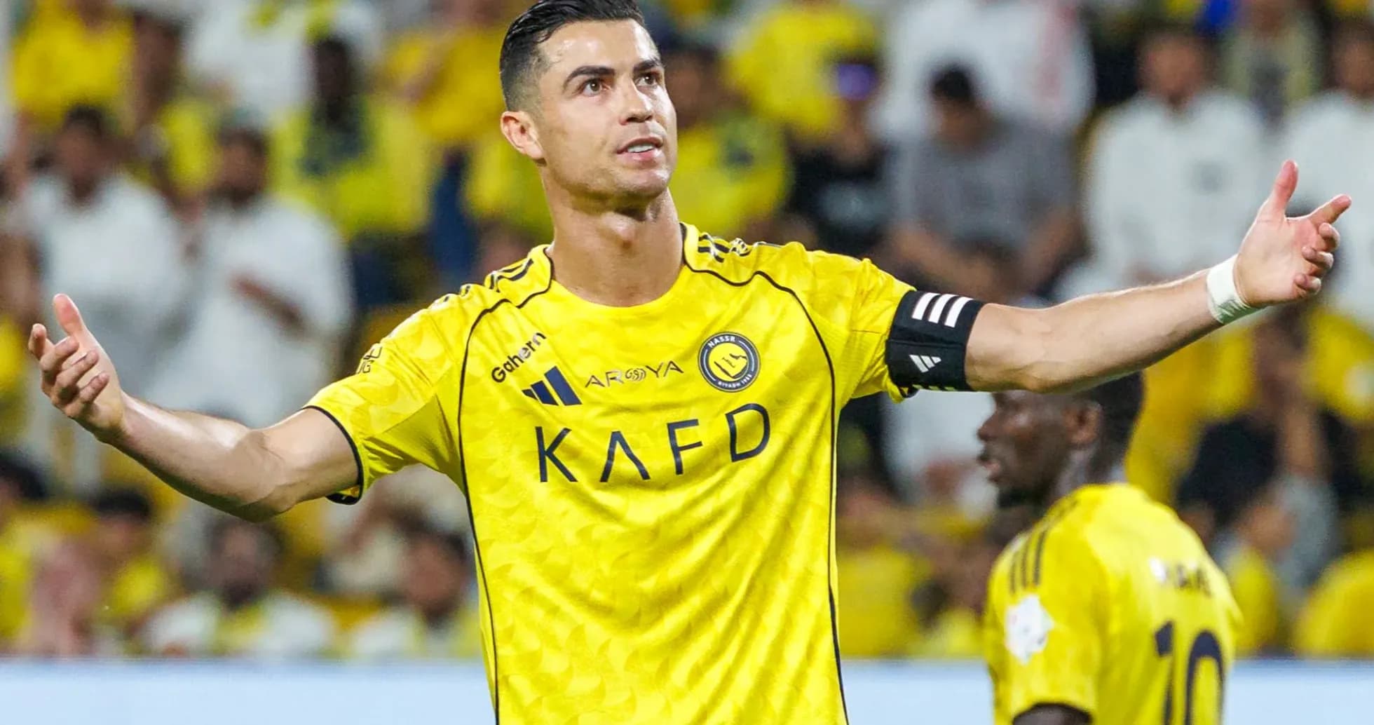 Futbolçu yellow jersey ilə komanda yoldaşlarına işarə edir
