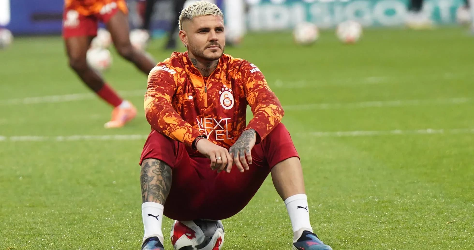 Futbolçu topun üstündə oturub məşq edir