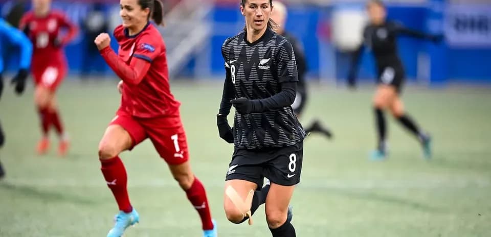 New Zealand player in black jersey running with ball