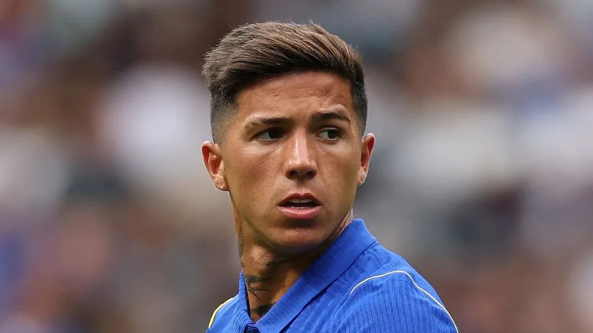 Futbolçu mavi forma ilə meydanda diqqətlə baxır