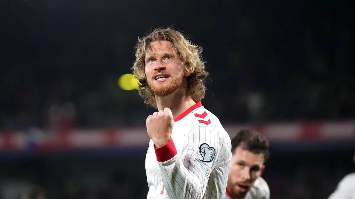 Futbolçu sevinclə əlini havaya qaldırır