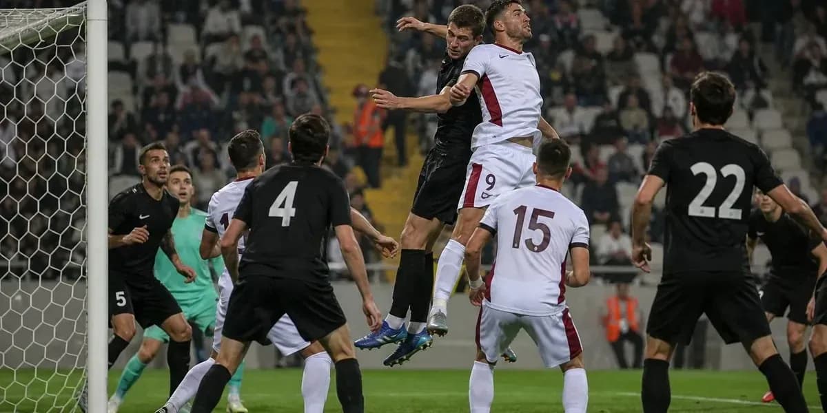 Players competing for a header near the goal
