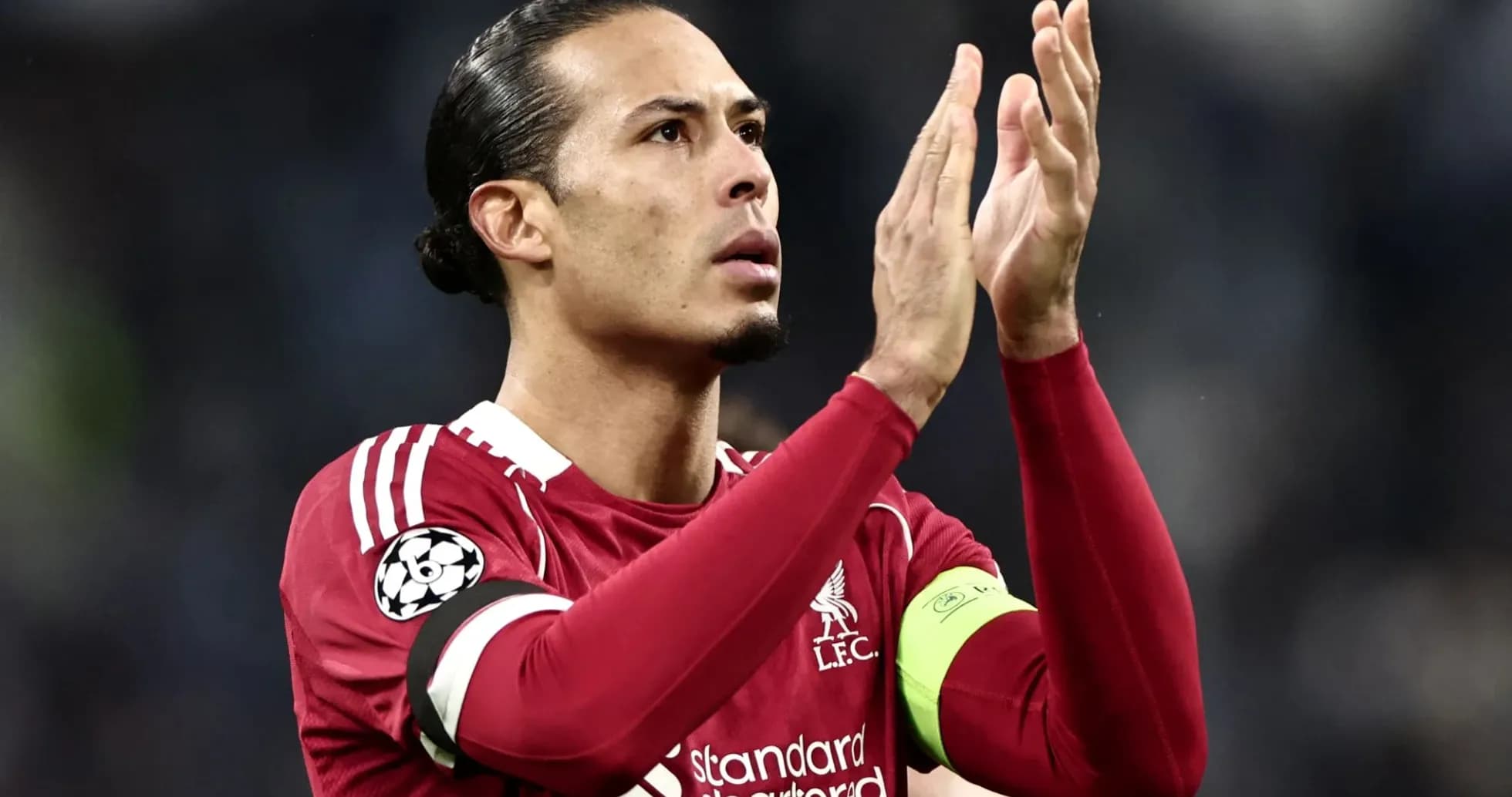 Futbolçu alqış edərək tərəfdarları selamlayır