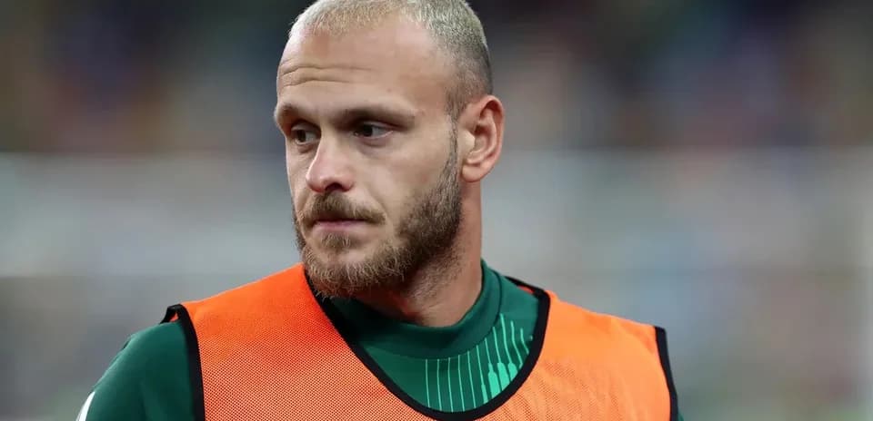 Futbolçu, ehtiyat oyunçusu forması ilə durur