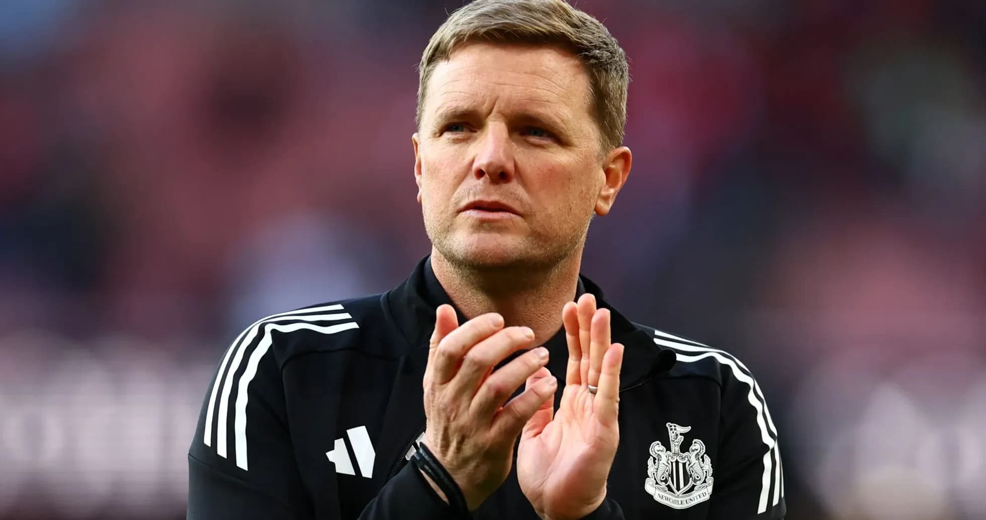 Newcastle United manager clapping on the pitch