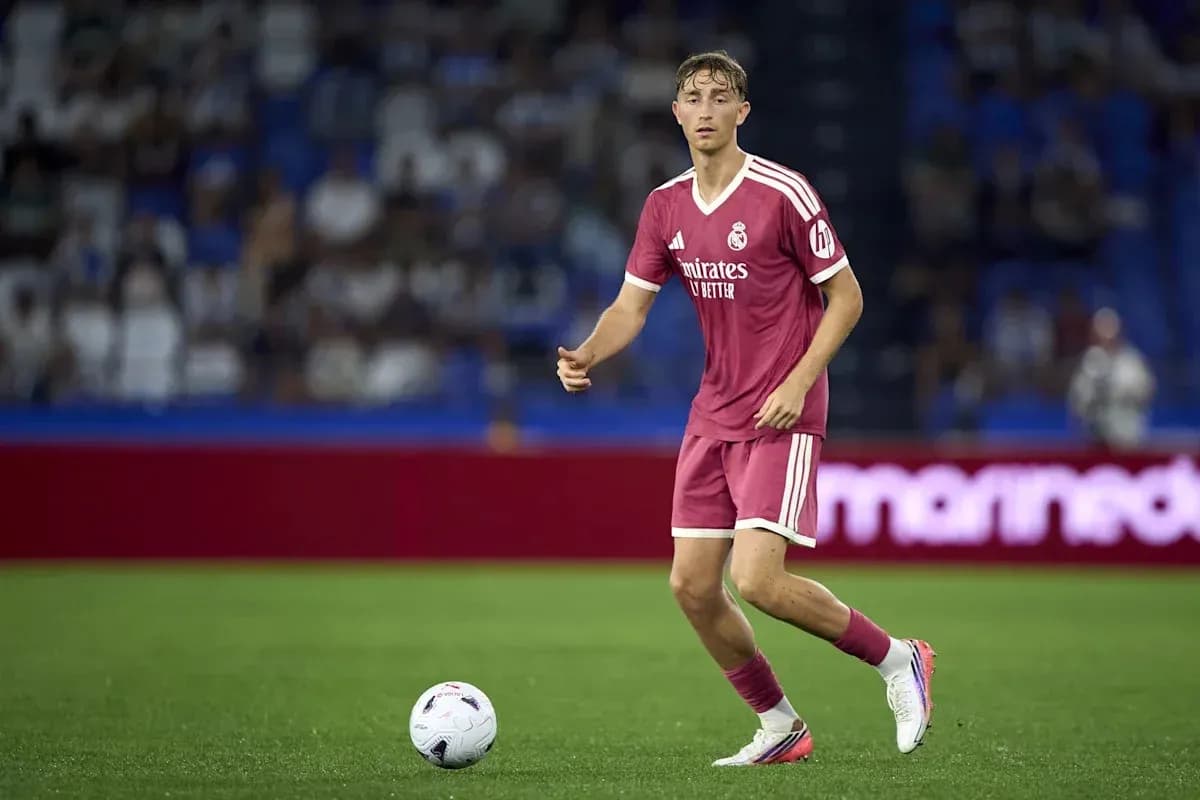 Futbolçu topa doğru yönelir, arka planda azarkeşlər