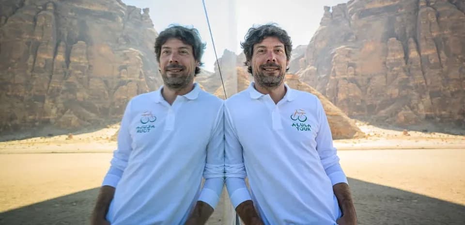 Adam dağların fonunda, polo köynəkdə dayanır