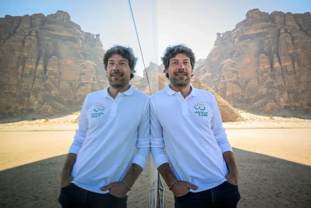 Adam dağların fonunda, polo köynəkdə dayanır