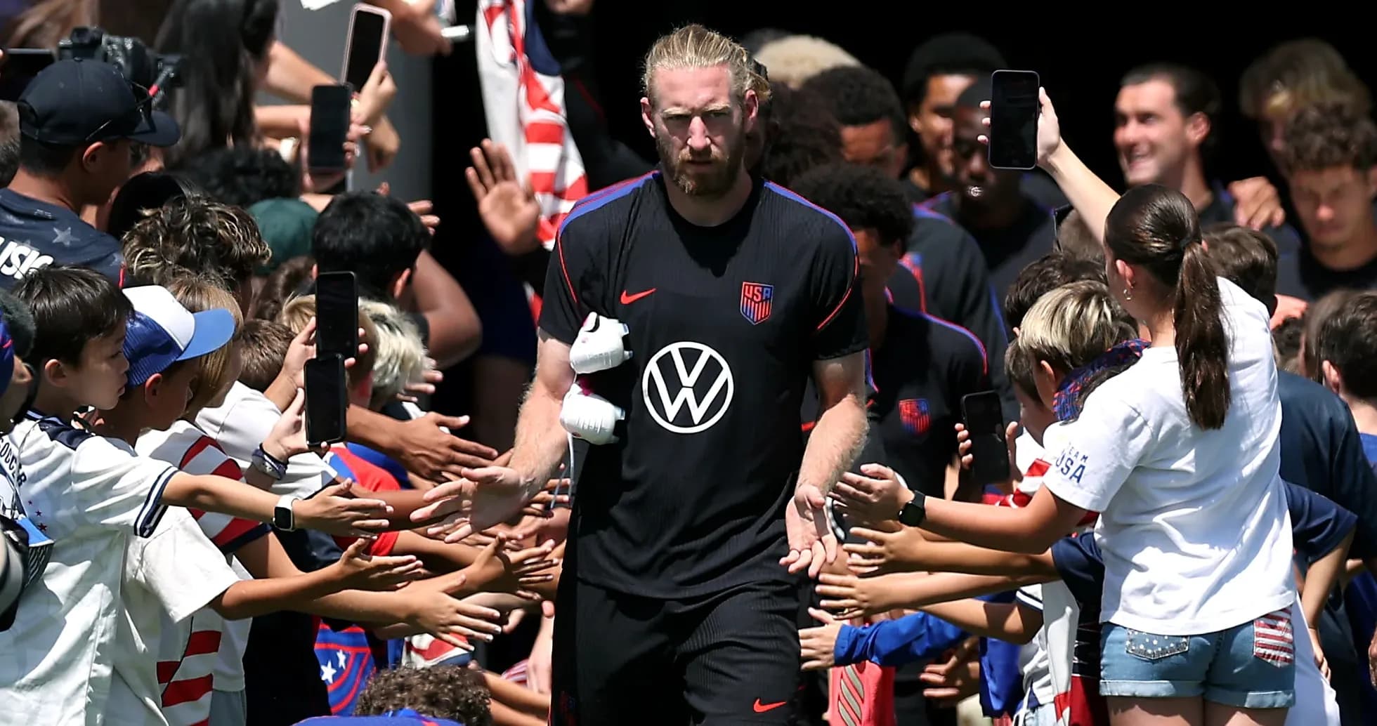 USA futbolçusu uşaqlarla salamlaşır