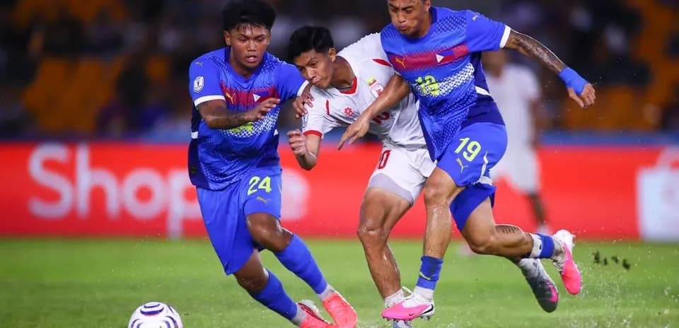Two players challenging an opponent for the ball
