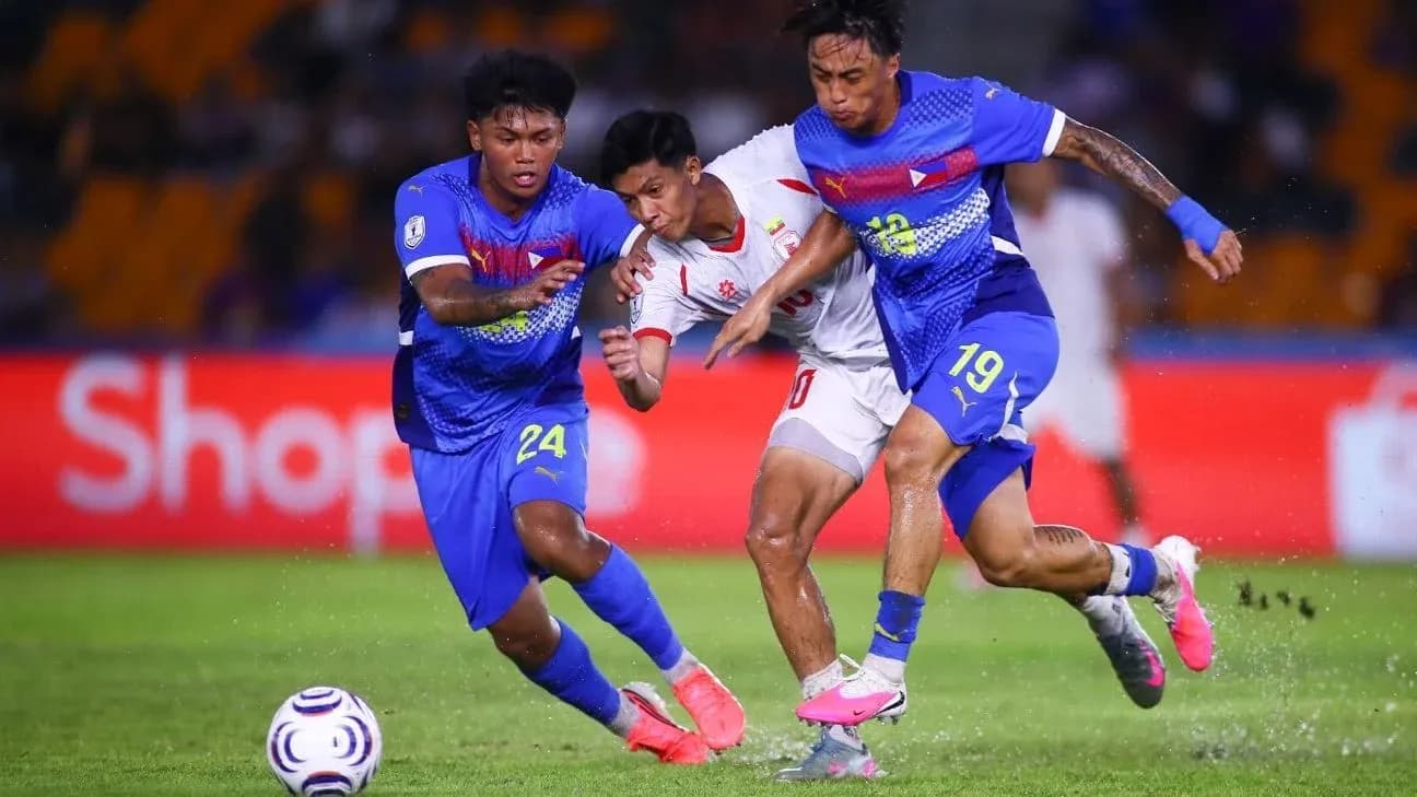 Two players challenging an opponent for the ball