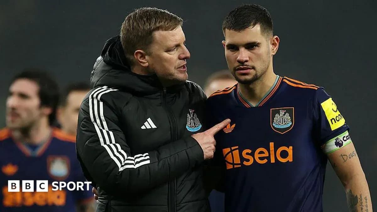 Newcastle United manager speaking to player on pitch