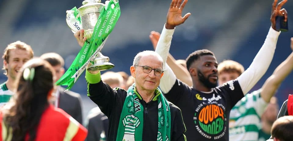 Celtic manager celebrating with trophy and fans