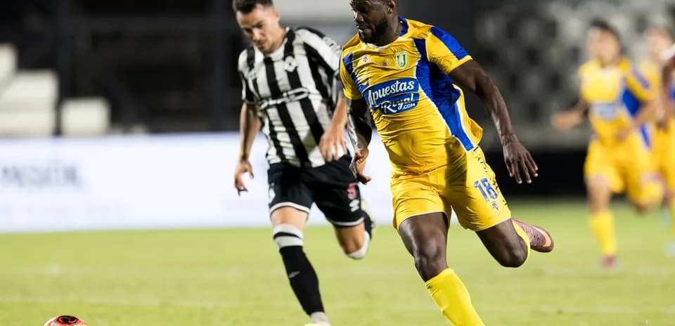 Futbol matçında futbolçular topu izləyir