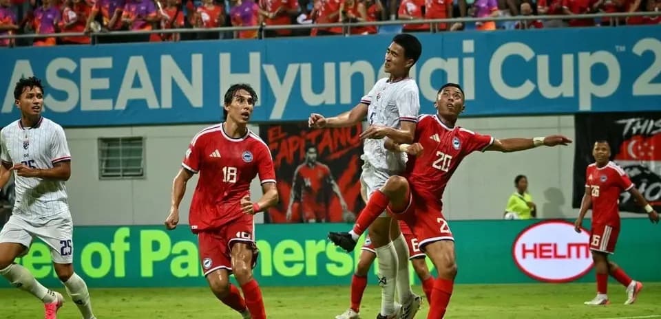 Players contesting a high ball during football match