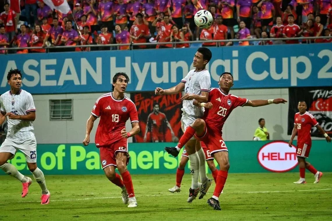 Players contesting a high ball during football match