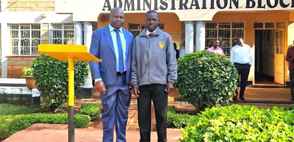 Two men posing in front of school administration block
