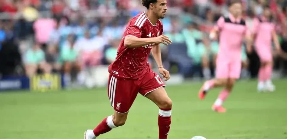 Futbolçu topu sürərək irəliləyir