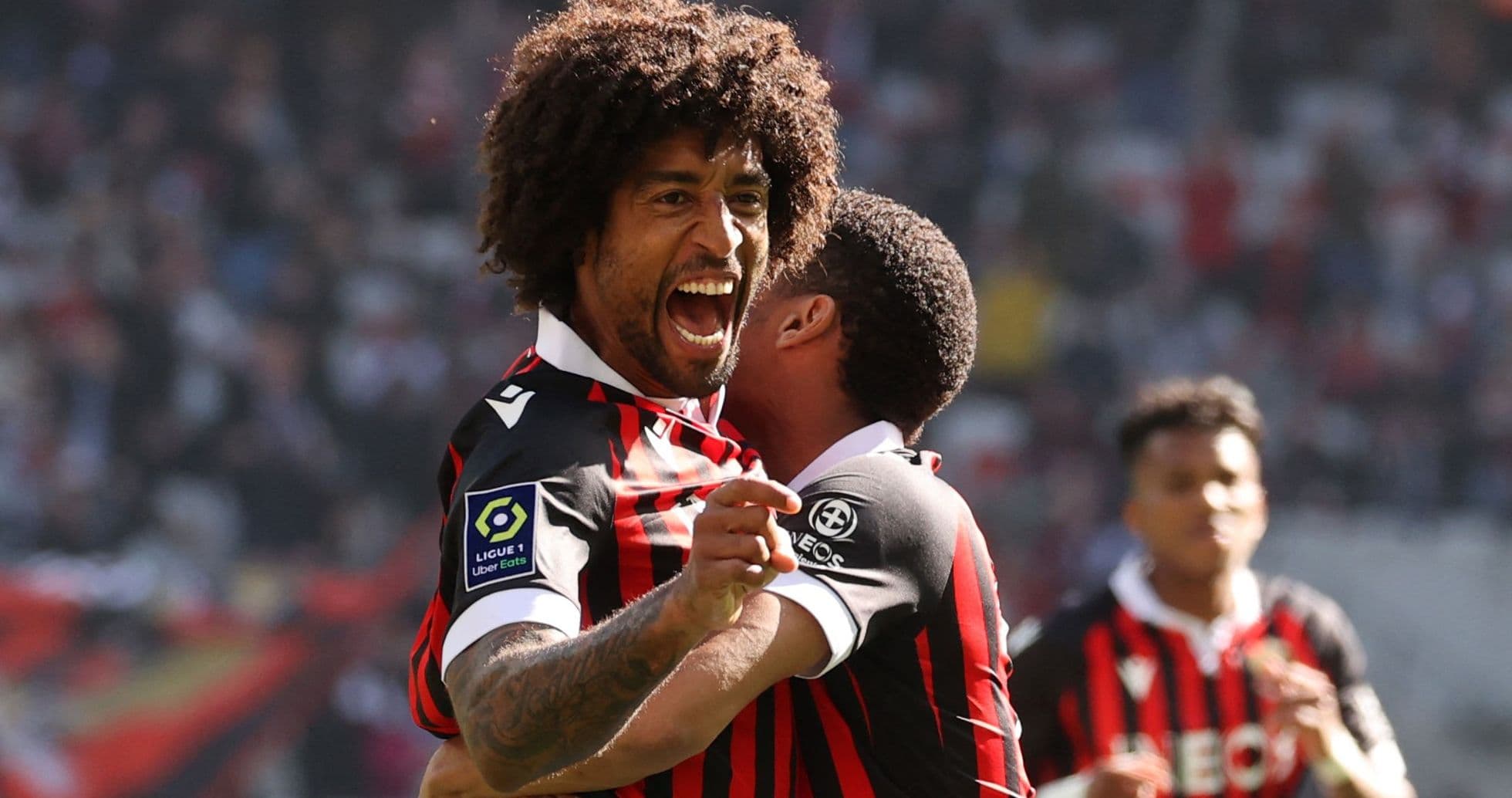 Futbolçu sevinclə digər oyunçunu qucaqlayır
