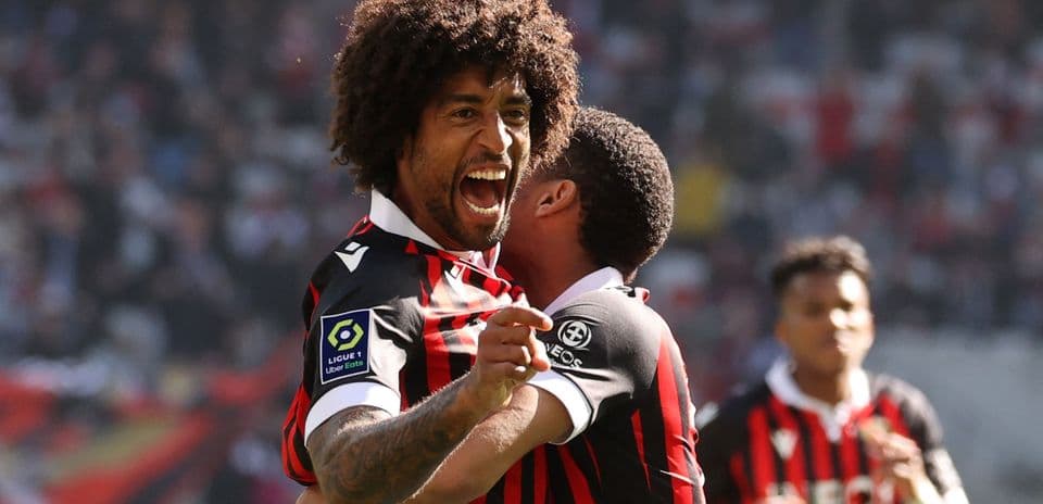 Futbolçu sevinclə digər oyunçunu qucaqlayır