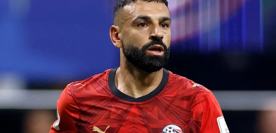 Futbolçu qırmızı forma ilə meydanda hərəkət edir