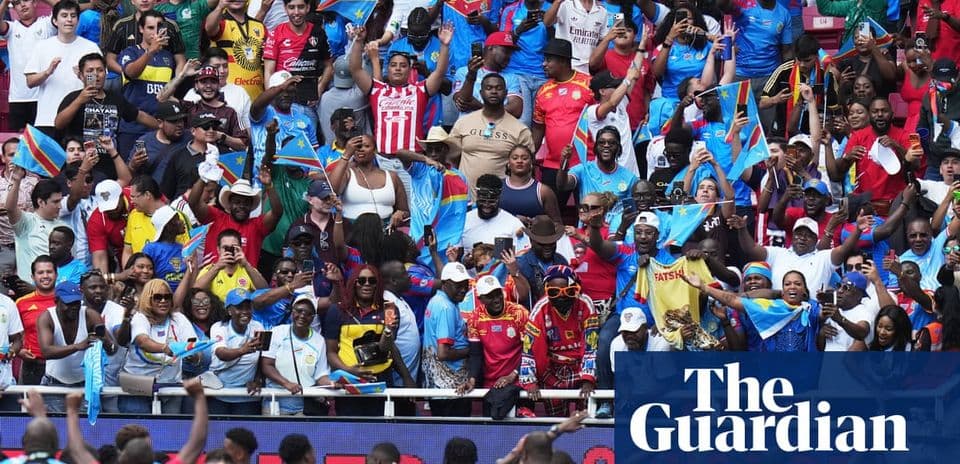 Crowd of fans waving flags at sports event
