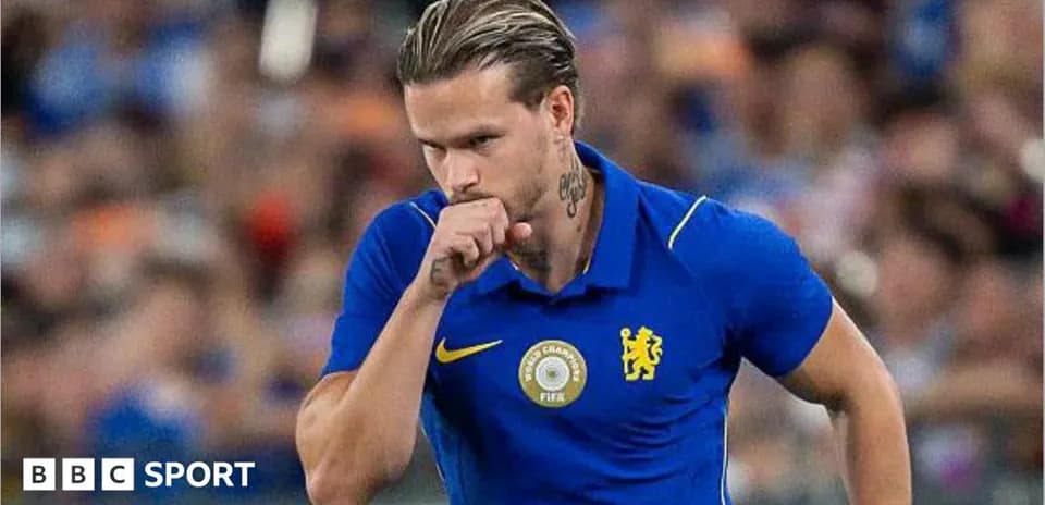 Futbolçu mavi forma ilə meydanda yürüyür