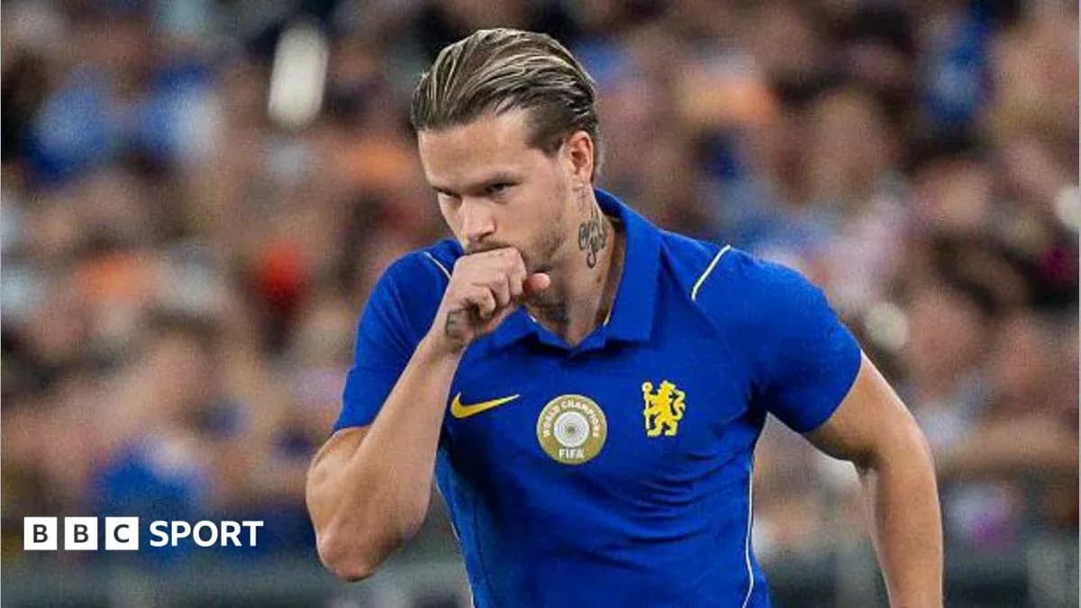 Futbolçu mavi forma ilə meydanda yürüyür