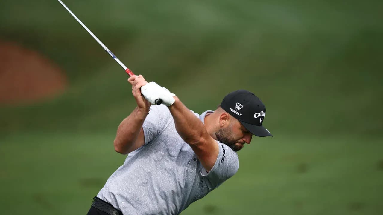 Golf player swinging club on course