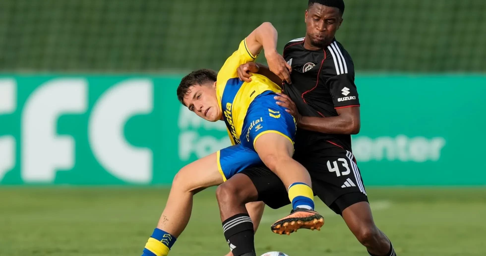 Two players battling for the ball on the field
