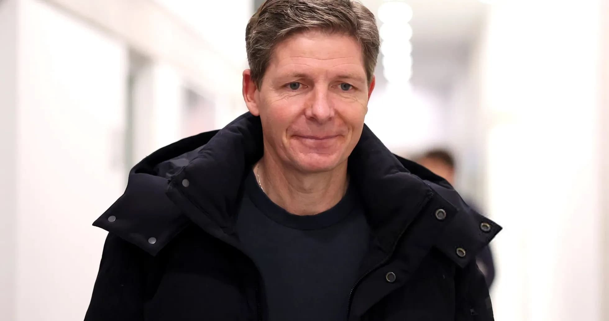 Man walking in a corridor wearing a jacket