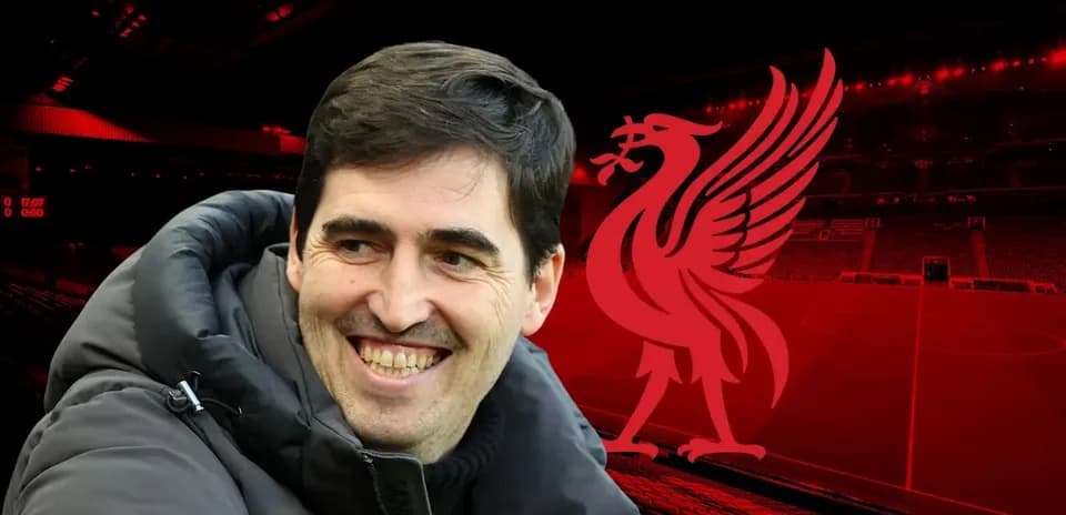 Coach smiling in front of Anfield stadium backdrop