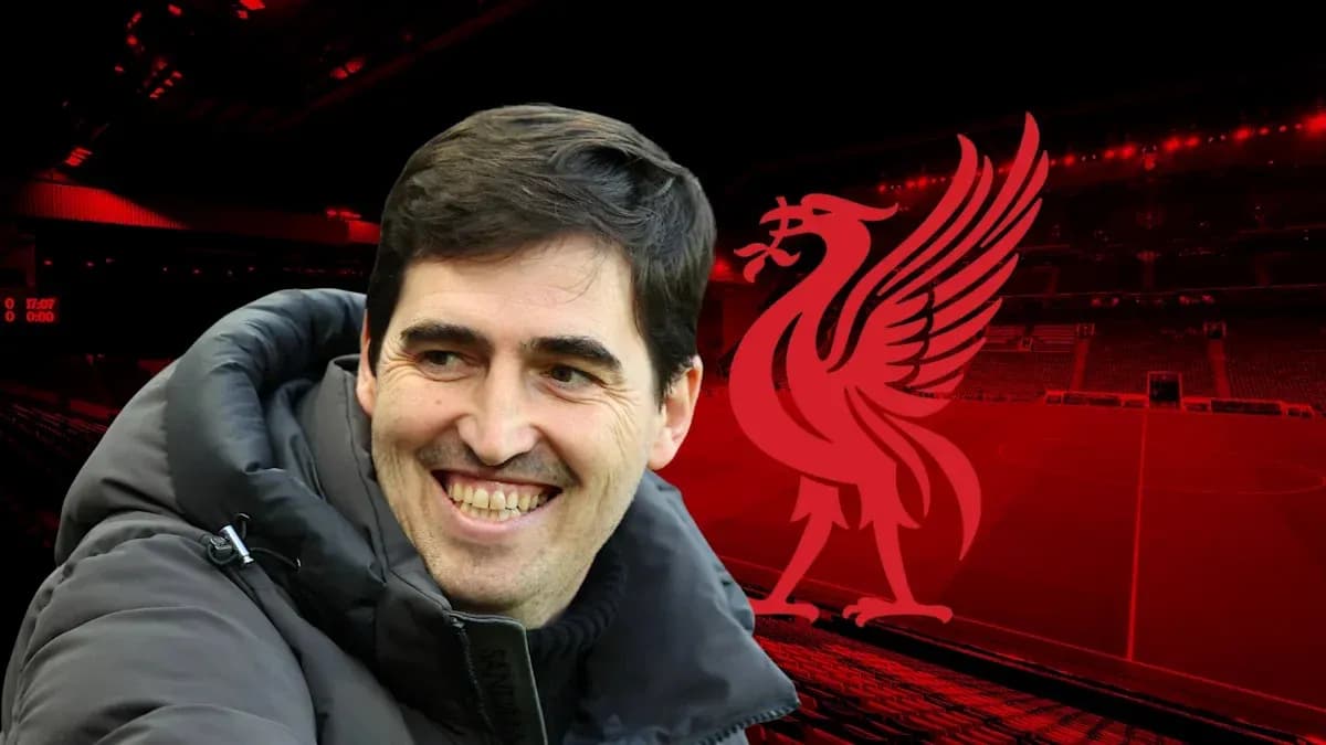 Coach smiling in front of Anfield stadium backdrop