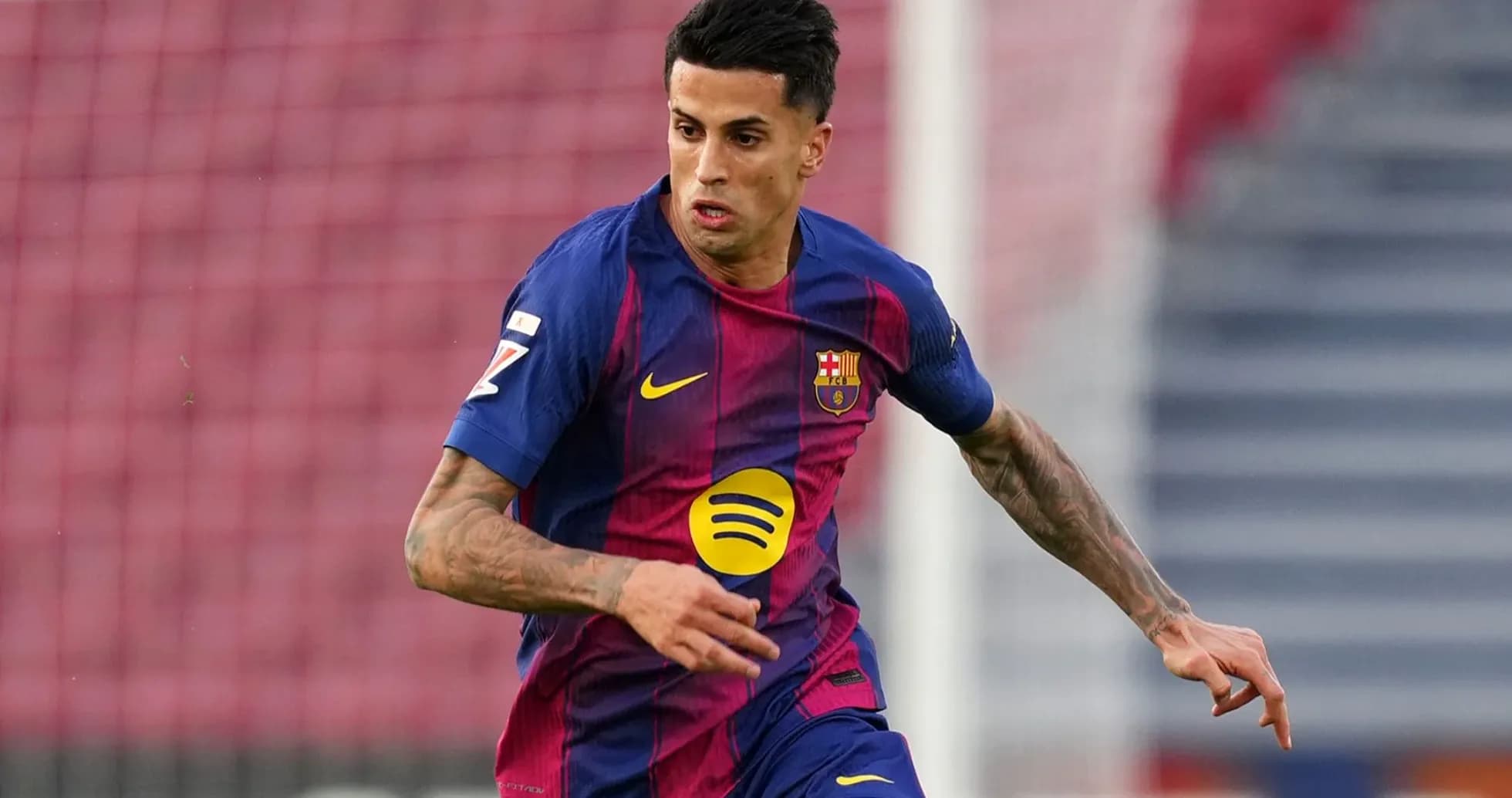 Futbolçu Barcelona formasında topa doğru irəliləyir