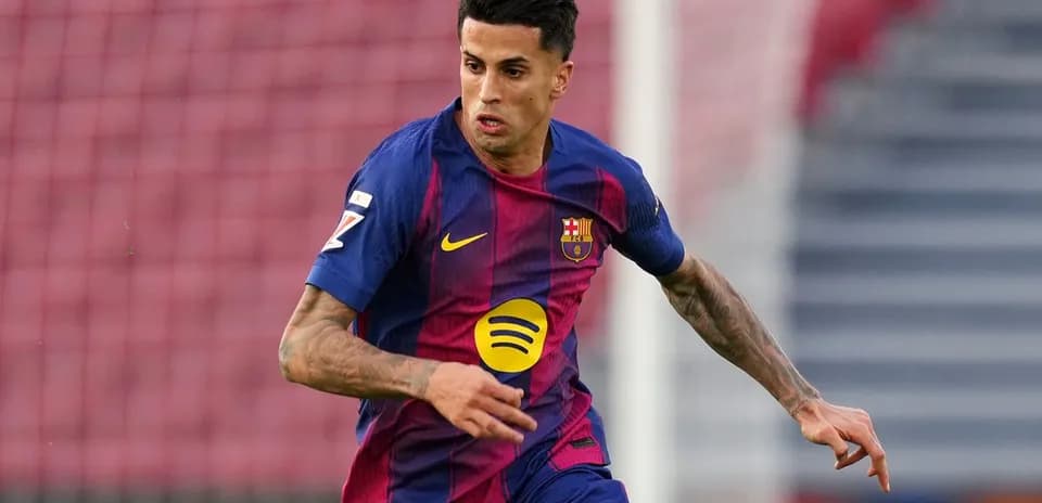 Futbolçu Barcelona formasında topa doğru irəliləyir