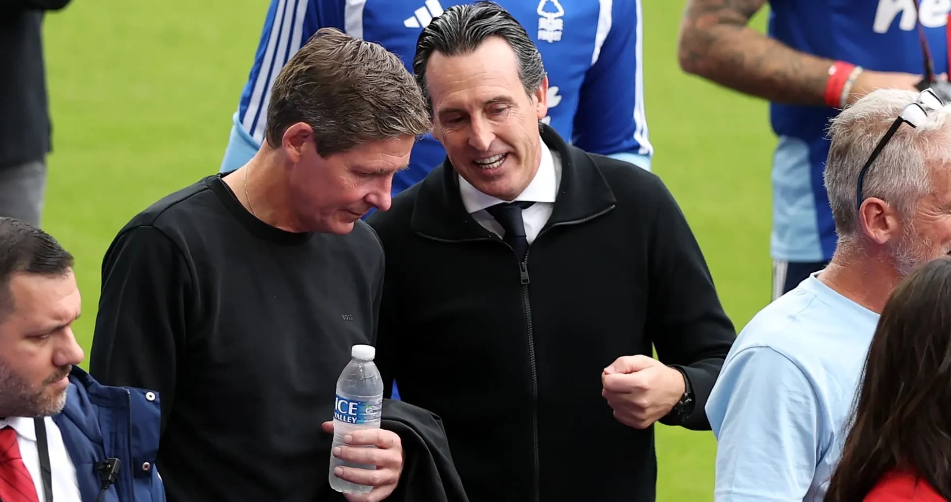 Two men conversing on the sidelines of a match