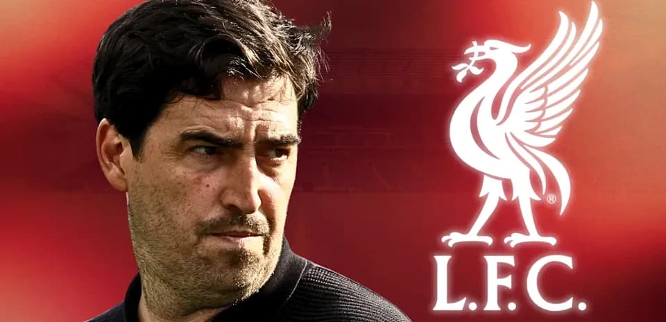 Football coach in front of Liverpool logo