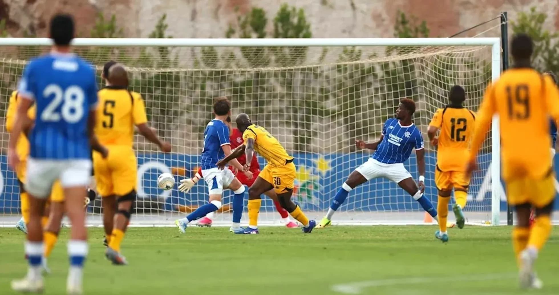 Player striking ball towards goal during match