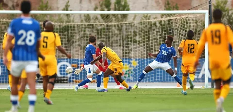 Player striking ball towards goal during match