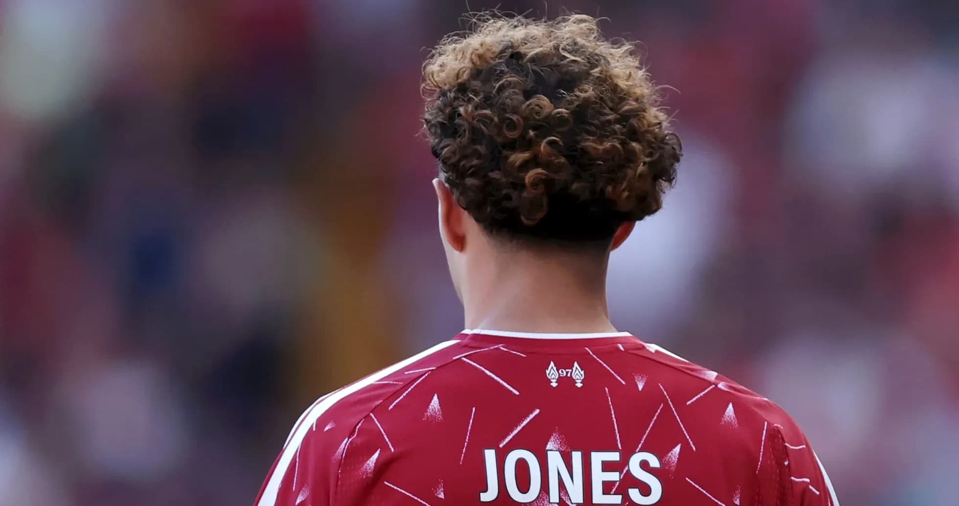 Futbolçu JONES, qırmızı forma ilə arxa planda
