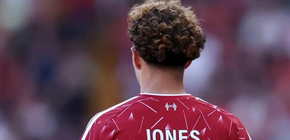 Futbolçu JONES, qırmızı forma ilə arxa planda