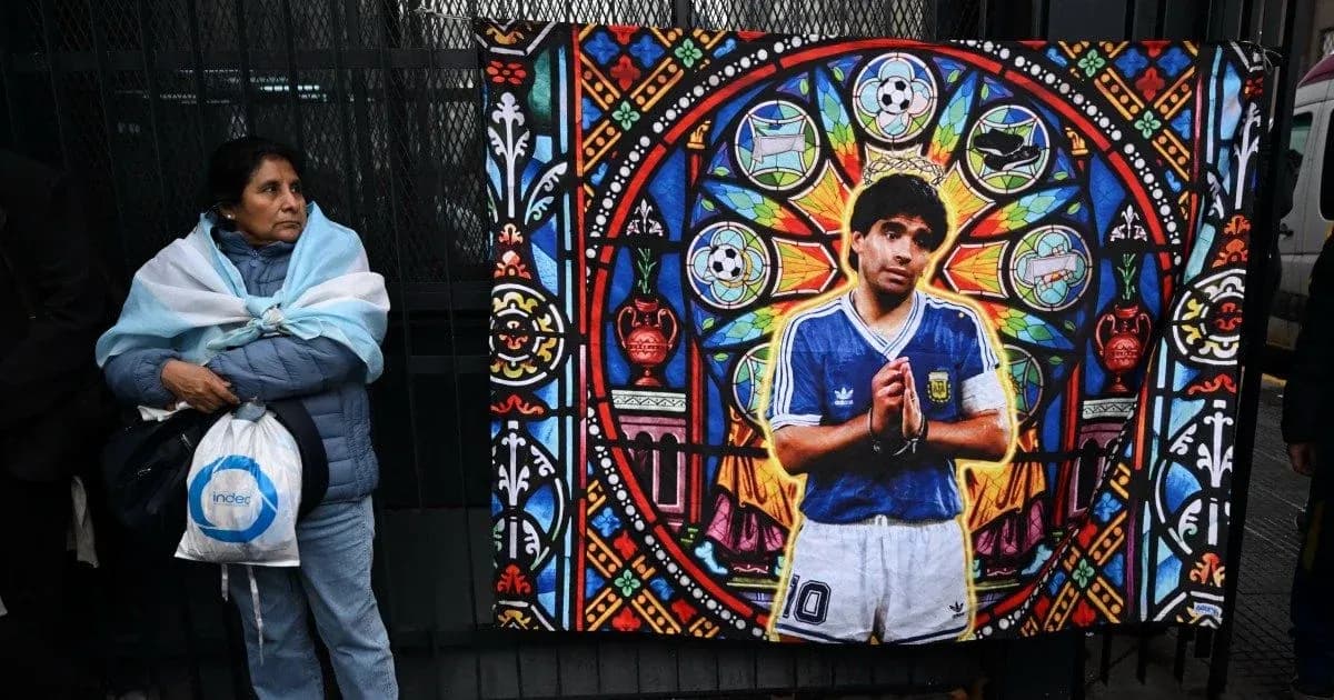 Woman beside mural of Diego Maradona in Argentina