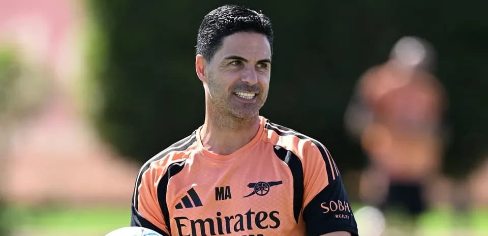 Men's football coach holding a ball during training