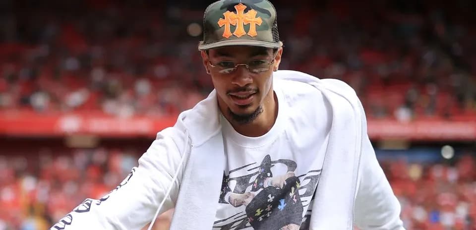 Player in casual attire greeting fans at stadium