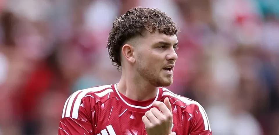 Futbolçu qırmızı forma ilə meydanda durur